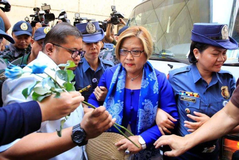 Philippine Senator Leila de Lima, who is detained on drug charges, looks at a flower given by her supporter upon arrival at a local court to face an obstruction of justice complaint in Quezon city, metro Manila, Philippines March 13, 2017.