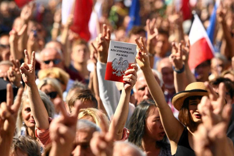 Manifestation à Cracovie le 16 juillet 2017, lors de laquelle un manifestant brandit un exemplaire de la Constitution polonaise. 
