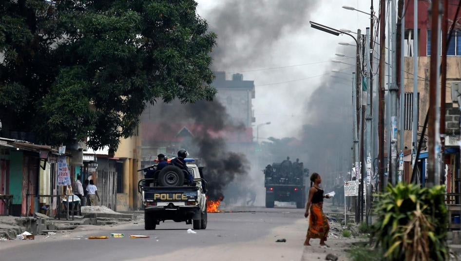 Des policiers congolais passent à côté d’une barricade en feu lors de manifestations à Kinshasa, la capitale de la République démocratique du Congo, le 20 décembre 2016. 