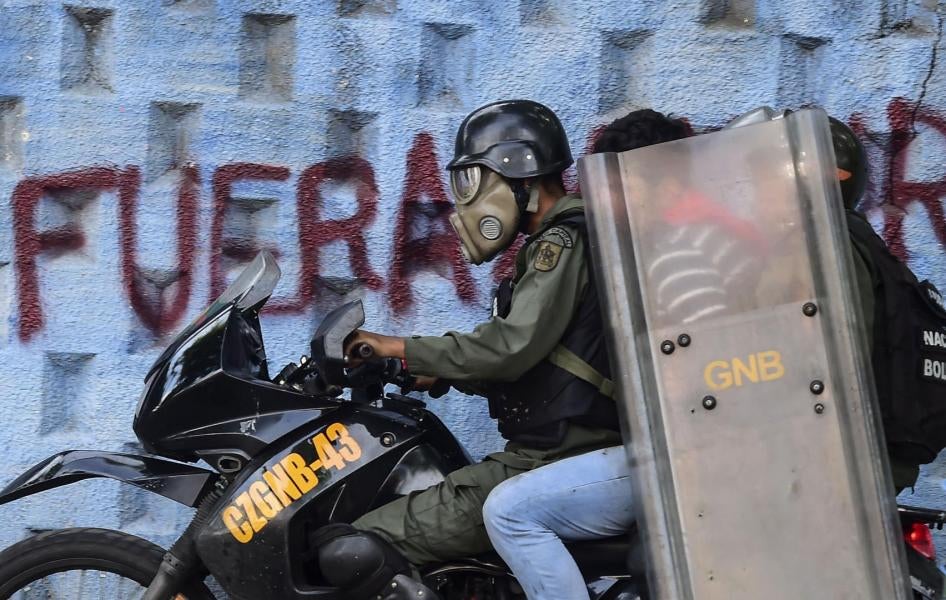 Un jeune homme arrêté lors d’une manifestation à Caracas, au Venezuela, est embarqué sur une motocyclette par deux membres de la Garde nationale bolivarienne (GNB), le 27 juillet 2017.