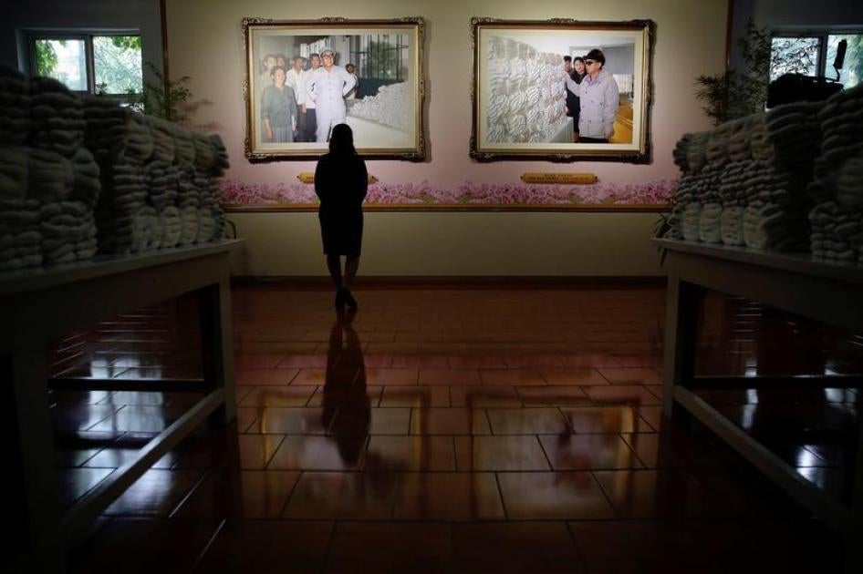 A woman stands before pictures of former North Korean leaders Kim Il Sung and Kim Jong Il visiting the Kim Jong Suk Pyongyang textile mill during a government organised visit for foreign reporters to the factory in Pyongyang, North Korea May 9, 2016.
