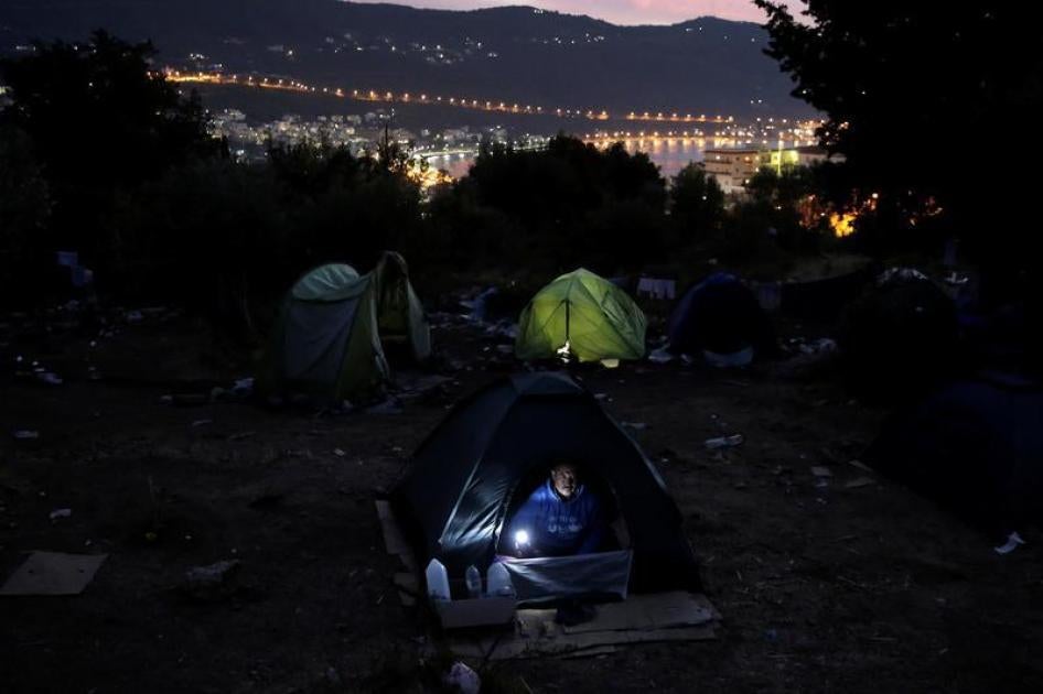 An asylum seeker is seen inside his tent at a makeshift camp on the Greek island of Samos, Greece. 
