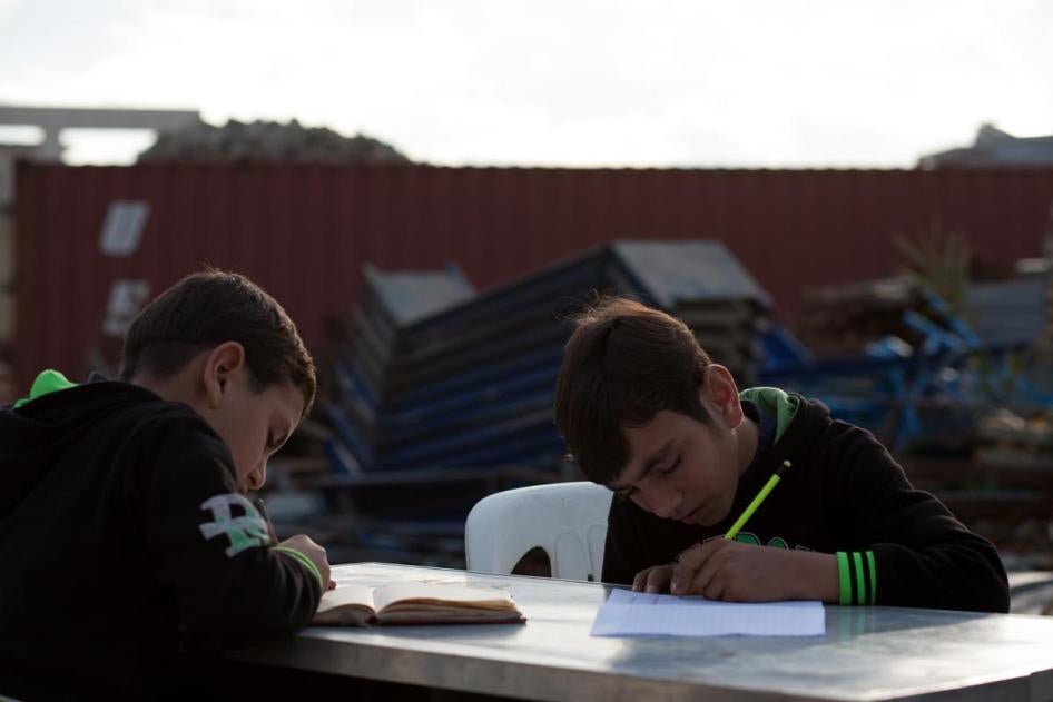 Brothers Wa’el, 12, and Fouad, 7, study on a desk outside their makeshift home in Jounieh, Lebanon.