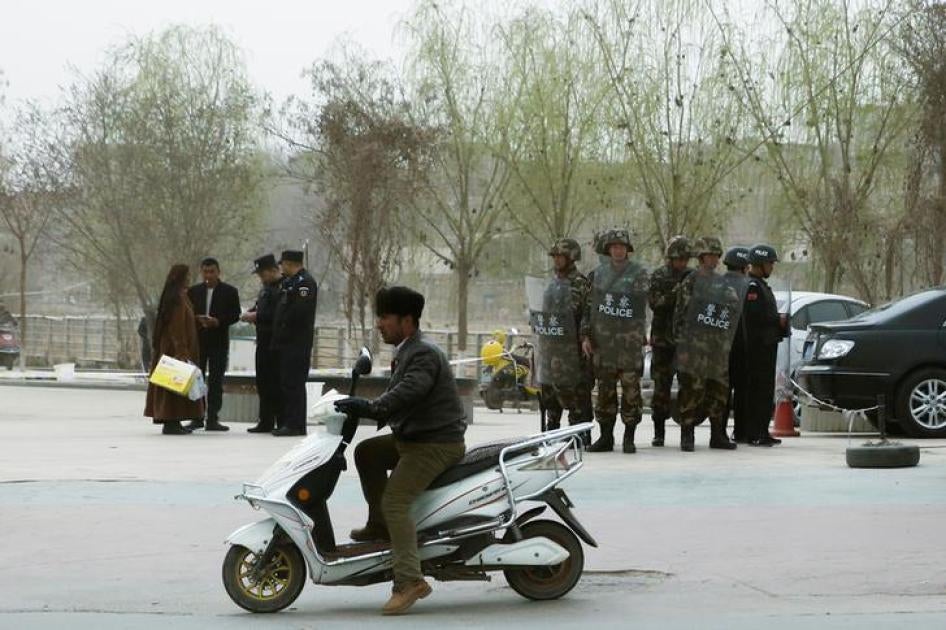 Polisi memeriksa kartu identitas orang-orang sementara pasukan keamanan mengawasi jalanan di Kashgar, Daerah Otonomi Xinjiang Uighur, Tiongkok pada 24 Maret 2017.