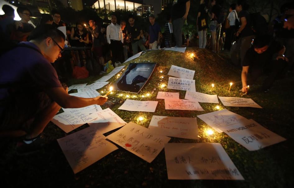 在芳林公园一隅的“演说者角落"，人们在标语旁燃点烛光，声援香港占领运动的示威者，2014年10月1日，新加波。