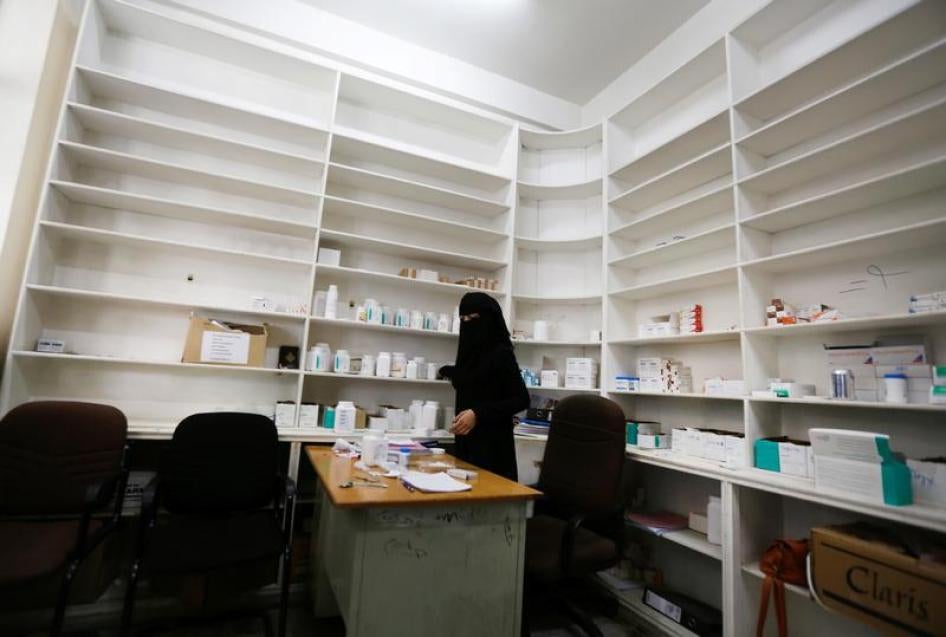 Une employée d'un hôpital gouvernemental à Sanaa, au Yémen, photographiée le 16 août 2017 devant des étagères pratiquement vides d’une pièce ou sont normalement stockés divers médicaments.