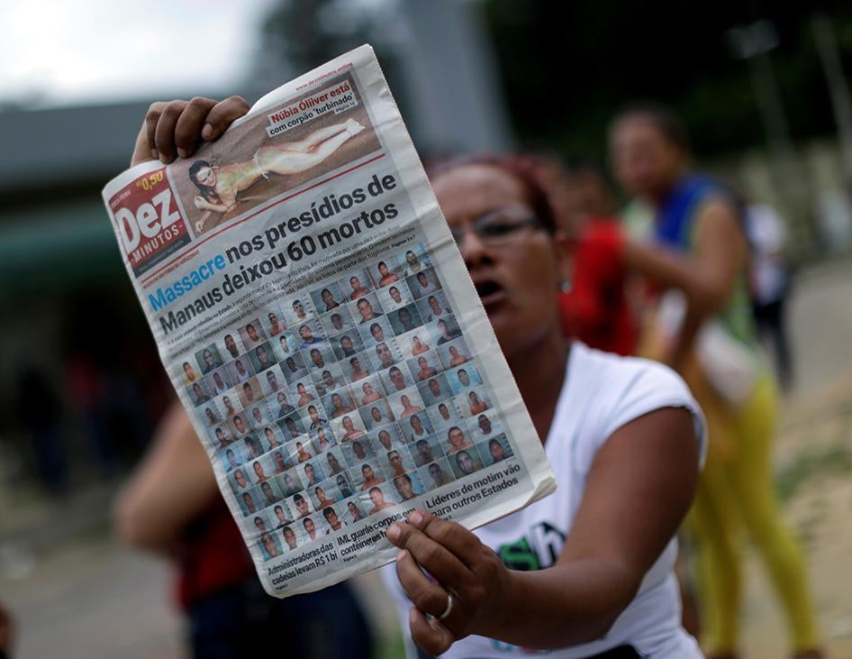 A relative of a prisoner holds a local newspaper, which shows a headline about a deadly prison riot, in front of Anisio Jobim prison in Manaus, Brazil, on January 3, 2017.