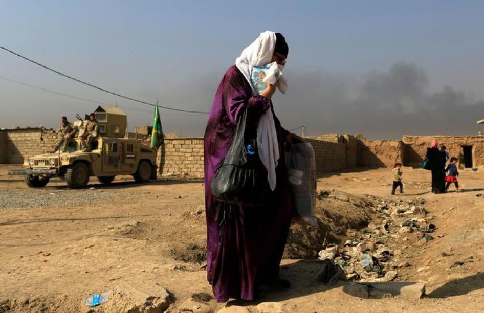 Une habitante du quartier d’Intisar, dans l’est de Mossoul, en Irak, fuyant cette zoneavec d’autres personnes le 7 novembre 2016, lors de l’offensive menée par les forces irakiennes contre les combattants de l'État islamique qui s’étaient emparés de Mosso