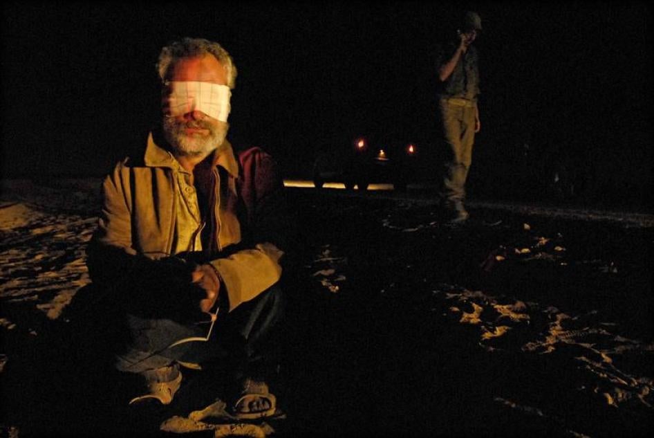 A blindfolded Palestinian, detained during an Israeli military operation in Gaza, sits on the ground at a crossing between Israel and the Gaza Strip on November 7, 2007. 