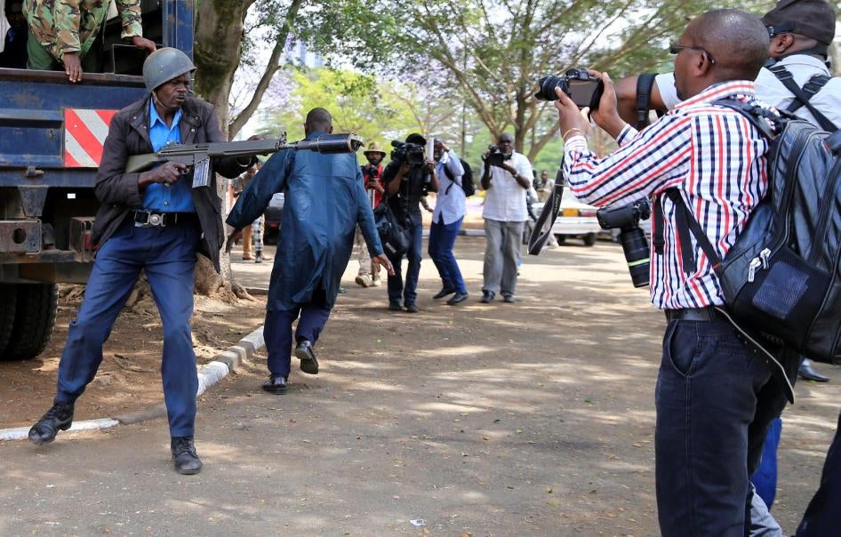 Un membre des forces de l’ordre antiémeutes s’apprête à tirer une grenade lacrymogène alors que des journalistes couvrent une manifestation contre la corruption dans la capitale du Kenya, Nairobi, le 3 novembre 2016. 
