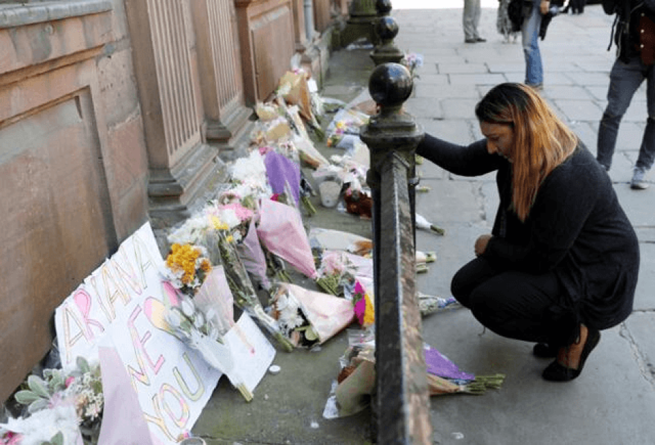 Une femme dépose des fleurs en hommage aux victimes de l’attentat meurtrier de Manchester Arena, à Manchester (Royaume-Uni), le 23 mai 2017.