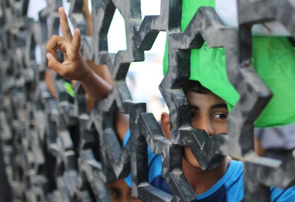 ילד פלסטיני משתתף בהפגנת מחאה, בשער של מעבר רפיח שבין מצרים לרצועת עזה, בנוגע לארבעה גברים פלסטיניים אשר, לפי הסברה, נמצאים במשמורת מצרים. ה-20 לאוגוסט 2015. 