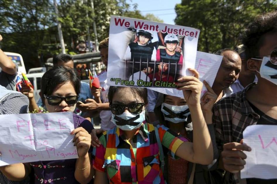 Protesters hold pictures of Zaw Lin and Win Zaw Htun as they protest in front of the Thai embassy in Rangoon on December 25, 2015. 