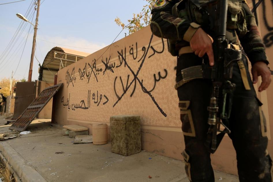  جندي من القوات الخاصة العراقية يقف بجانب كتابات على الحائط تقول "الدول الإسلامية باقية بإذن الله" في برطلة شرق الموصل، العراق أكتوبر/تشرين الأول 2016. © 2016 رويترز