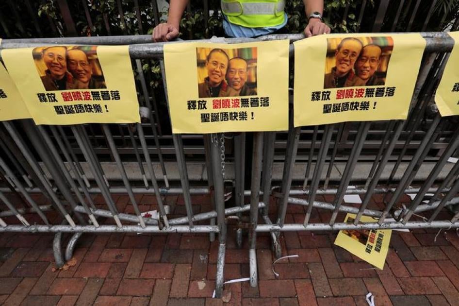被要求释放诺贝尔和平奖得主刘晓波的抗议人士，将刘晓波的照片贴在警方拒马上。