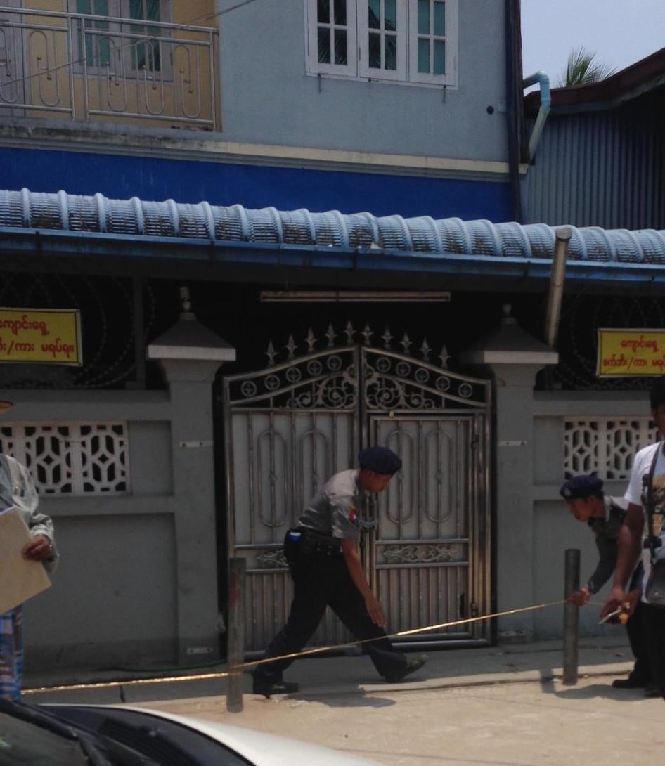 Police officers place yellow tape across the entrance to one of the madrasas in Thaketa Township, Rangoon, April 29, 2017. 