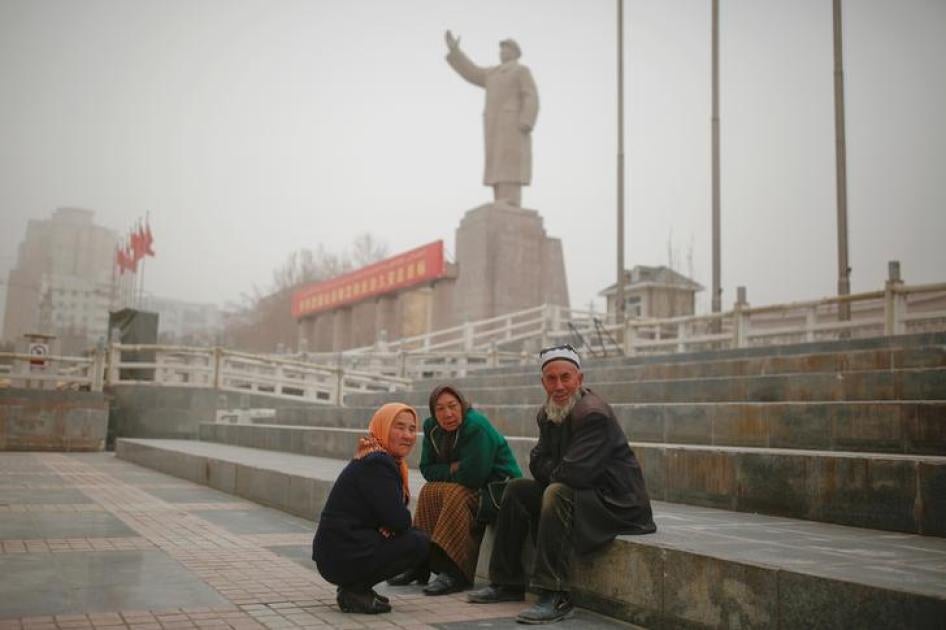 喀什地区的维族居民在已故中国人民政府主席毛泽东雕像下小憩，中国新疆维吾尔自治区，2017年3月23日。