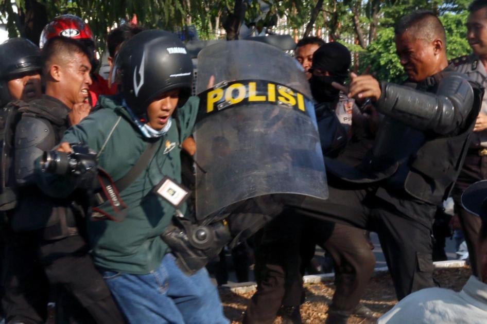A police officer kicks photographer Ikshan Arham of the Rakyat Sulsel newspaper during a  student protest at Makassar State University on November 13, 2014. Police allegedly assaulted 10 journalists that day, but no officers have been prosecuted for those