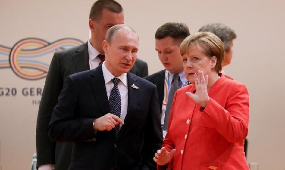 German Chancellor Angela Merkel talks to Russia's President Vladimir Putin at the start of the first working session of the G20 meeting in Hamburg, Germany, July 7, 2017