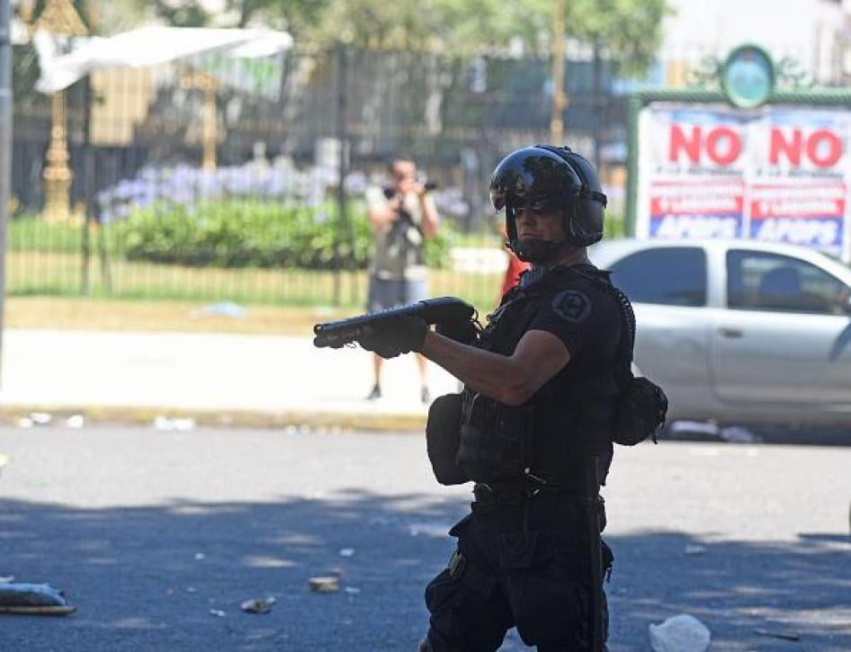 A member of Argentine National Gendarmerie aims his gun to demonstrators during a protest.