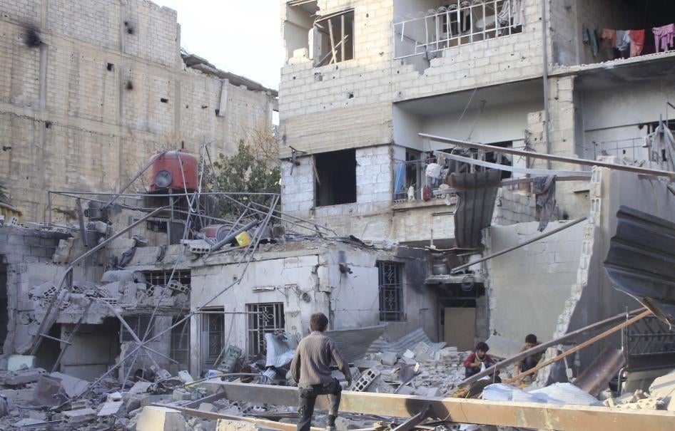 Des garçons photographiés parmi les décombres d'un bâtiment endommagé à Ghouta, une banlieue à l'est de Damas, en Syrie.