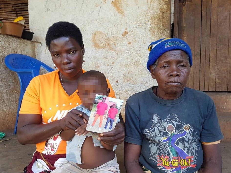The wife, son, and mother of Manuel Fungulane, with his photograph (man on left). Fungulane disappeared on August 13, 2016, after being detained by government soldiers. 