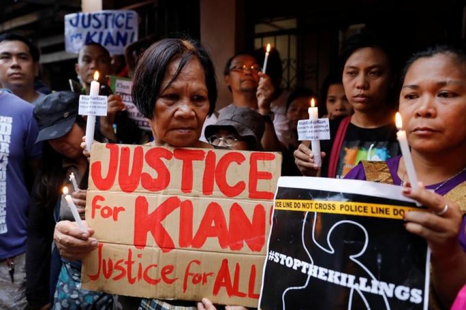Protesters hold placards and lit candles at the wake of Kian delos Santos, a 17-year-old high school student, who was among the people shot dead last week in an escalation of President Rodrigo Duterte's war on drugs, in Caloocan City, Metro Manila, Philip