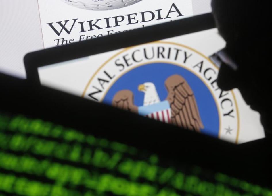 A man is seen near cyber code and the U.S. National Security Agency logo in this photo illustration taken in Sarajevo March 11, 2015.