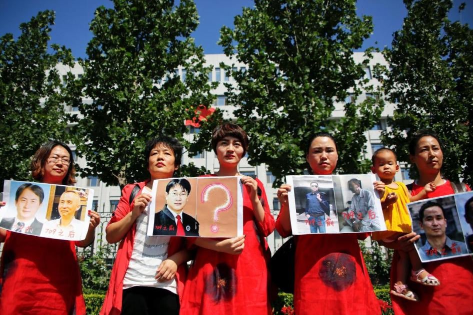 Des membres des familles d'avocats chinois arrêtés lors des opérations policières de juillet 2015 tiennent des photos des personnes détenues, lors d’un rassemblement devant le siège du Tribunal populaire suprême à Pékin, le 7 juillet 2017, à l’occasion du