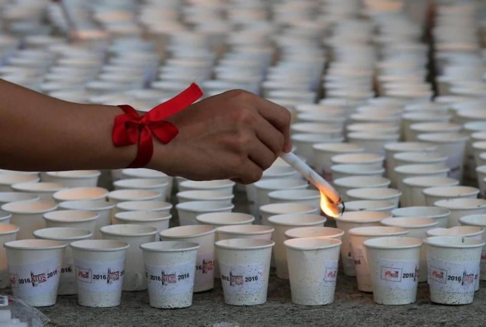 A supporter lights candles in commemoration of HIV/AIDS victims in the Philippines at a ceremony in Quezon City, Metro Manila, May 14, 2016. 