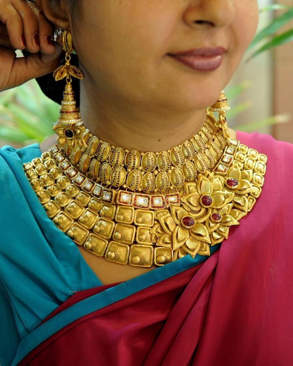 A woman tries on a necklace at the Tribhovandas Bhimji Zaveri (TBZ) showroom in Ahmedabad, India, August 2010. 