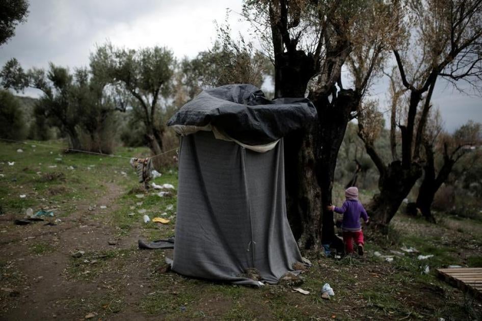 A girl walks next to a self-made shower at a makeshift camp for refugees and migrants next to the Moria camp on the island of Lesbos, Greece, November 30, 2017.