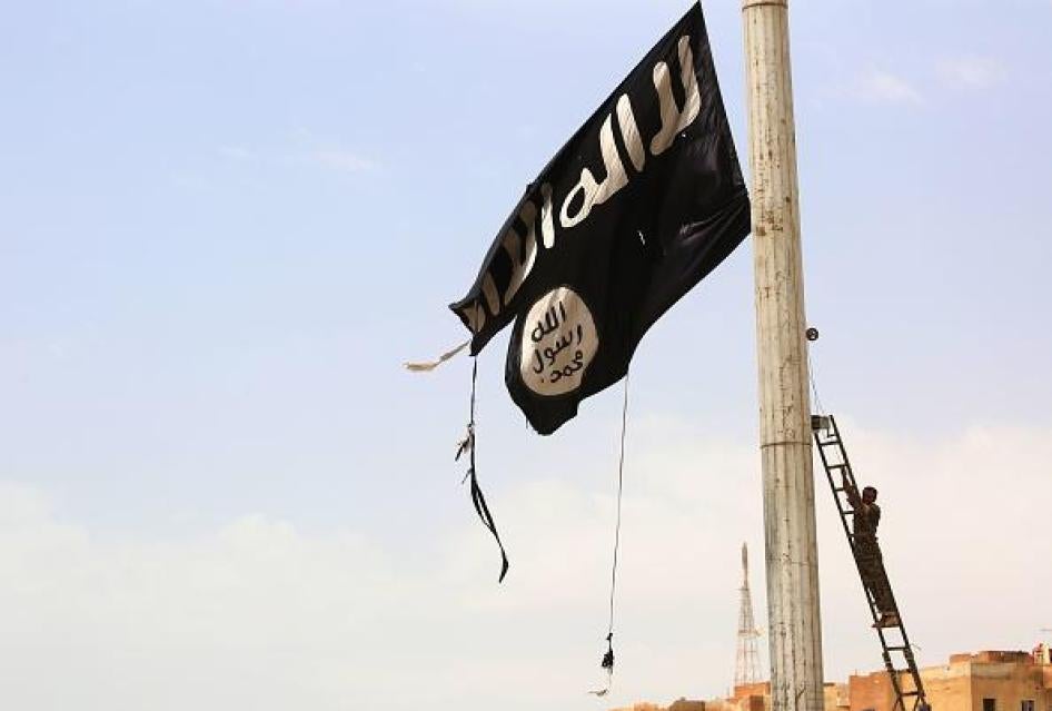 عضو في قوات سورية الديمقراطية يزيل علم تنظيم الدولة الإسلامية في بلدة الطبقة غرب مدينة الرقة، سوريا، 30 أبريل/نيسان 2017. © 2017 غيتي إيمجز