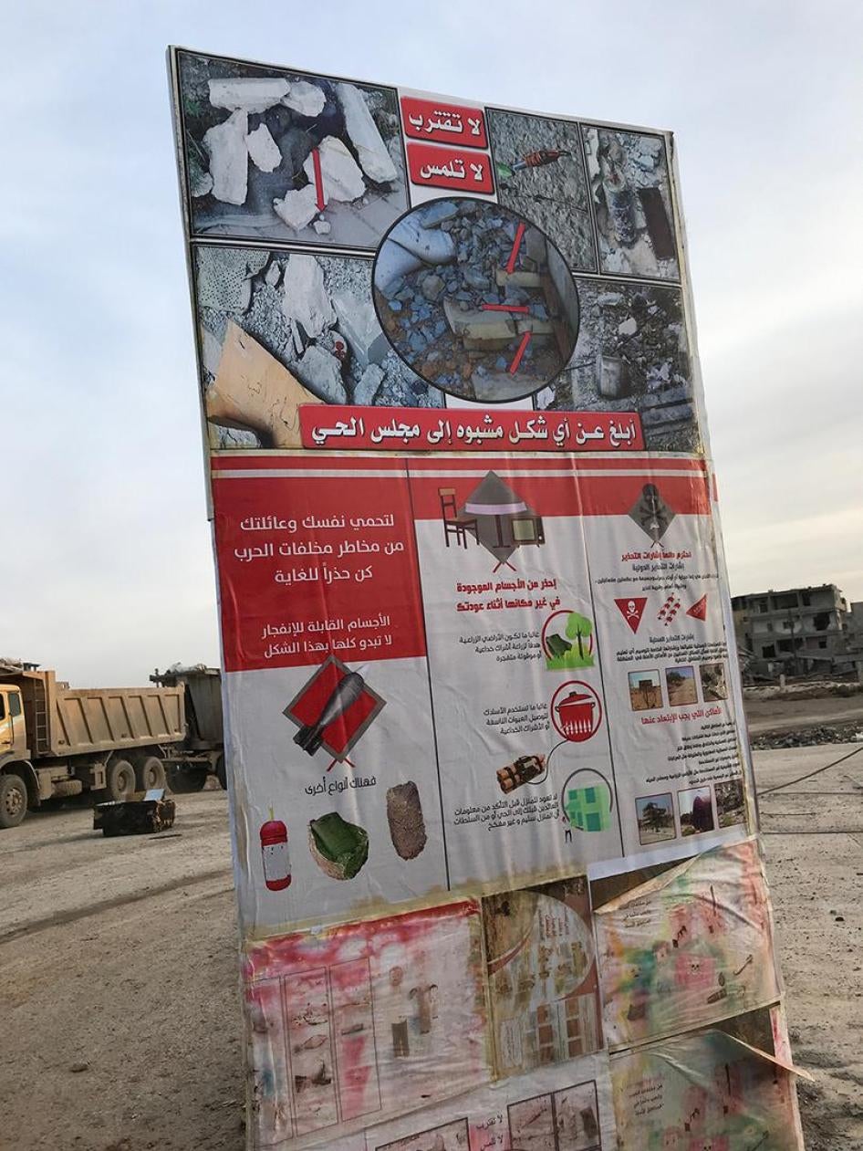 Une affiche érigée à un carrefour de à Raqqa, en Syrie, et photographié le 21 janvier 2018, avertit les résidents sur les graves dangers posés par des munitions non explosées (« restes explosifs de guerre ») ainsi que par des mines antipersonnel improvisé