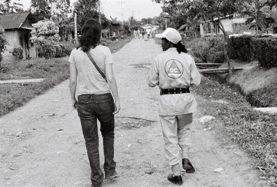 Maria McFarland Sánchez-Moreno of Human Rights Watch walks alongside a civilian protection officer in a small town near Tumaco, in the state of Nariño, Colombia, a day after a massacre by successors to the paramilitaries in the town, July 2009. 
