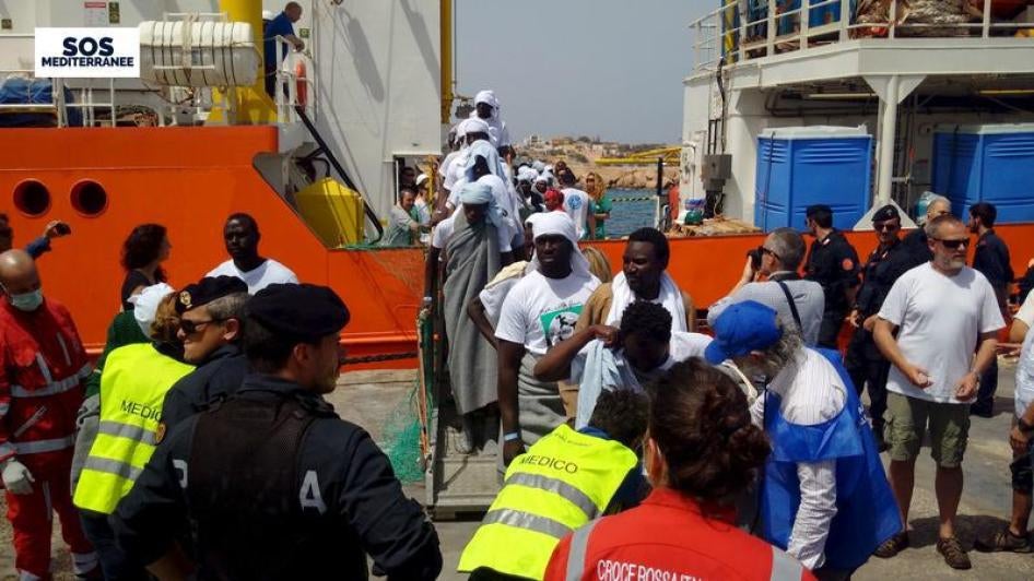 Des migrants africains débarquent du navire Aquarius, affrété par SOS Méditerranée pour des opérations de sauvetage en mer, peu après l’arrivée du bateau à l'île italienne de Lampedusa au large de l’Italie, le 18 avril 2016.