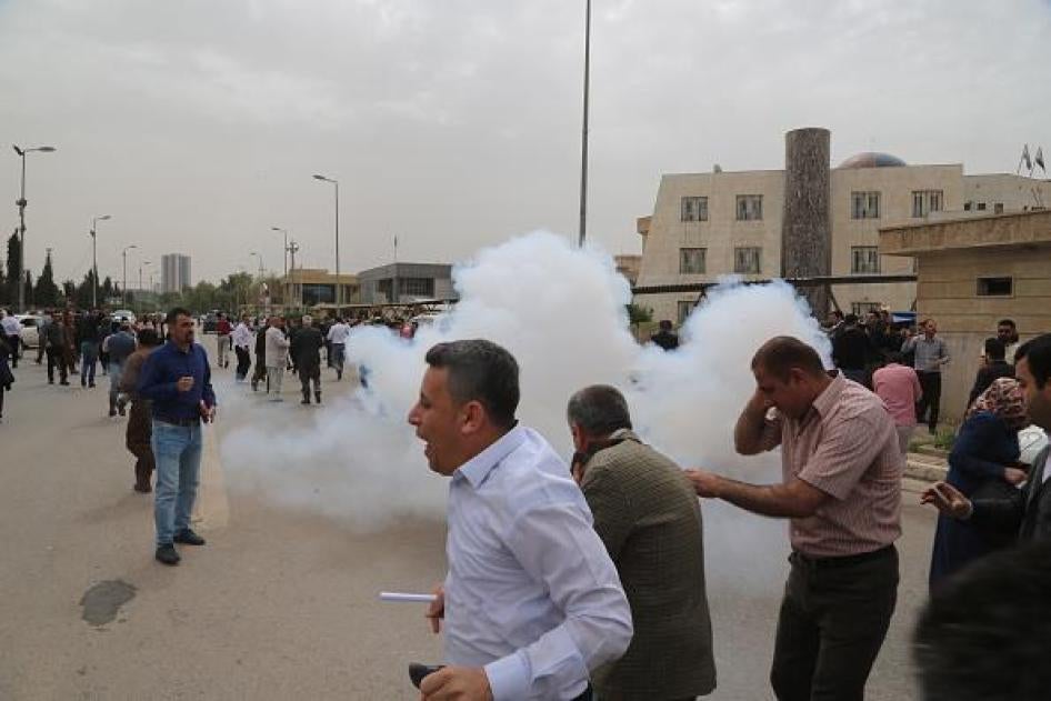 شرطة مكافحة الشغب تستخدم الغاز المسيل للدموع لتفريق مئات الموظفين الذين تجمعوا احتجاجا على الأجور المُخفّضة في أربيل، العراق، في 25 مارس/آذار 2018. © 2018 هيم بودان/وكالة الأناضول/غيتي ايمجز 