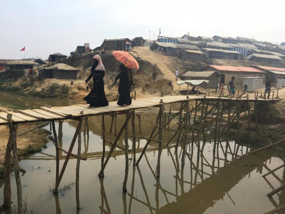 Rohingya refugees walk across a bamboo bridge in the Kutupalong camp in Bangladesh, February 11, 2018.