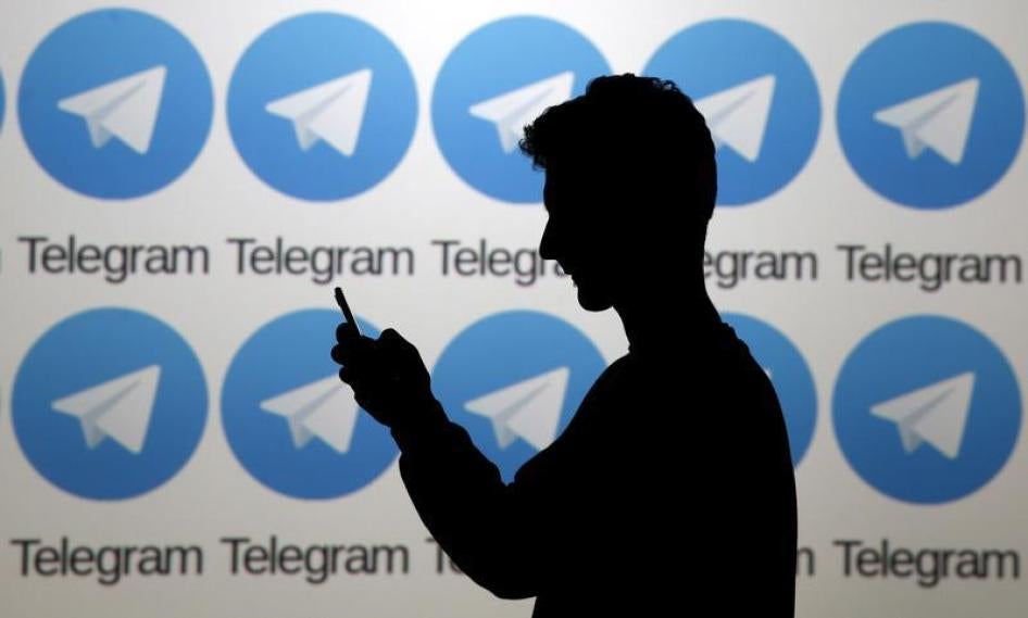 一位手机用户身后的大屏幕上排列著Telegram通讯软件的商标，波斯尼亚和黑塞哥维那，泽尼察市，2015年11月18日。