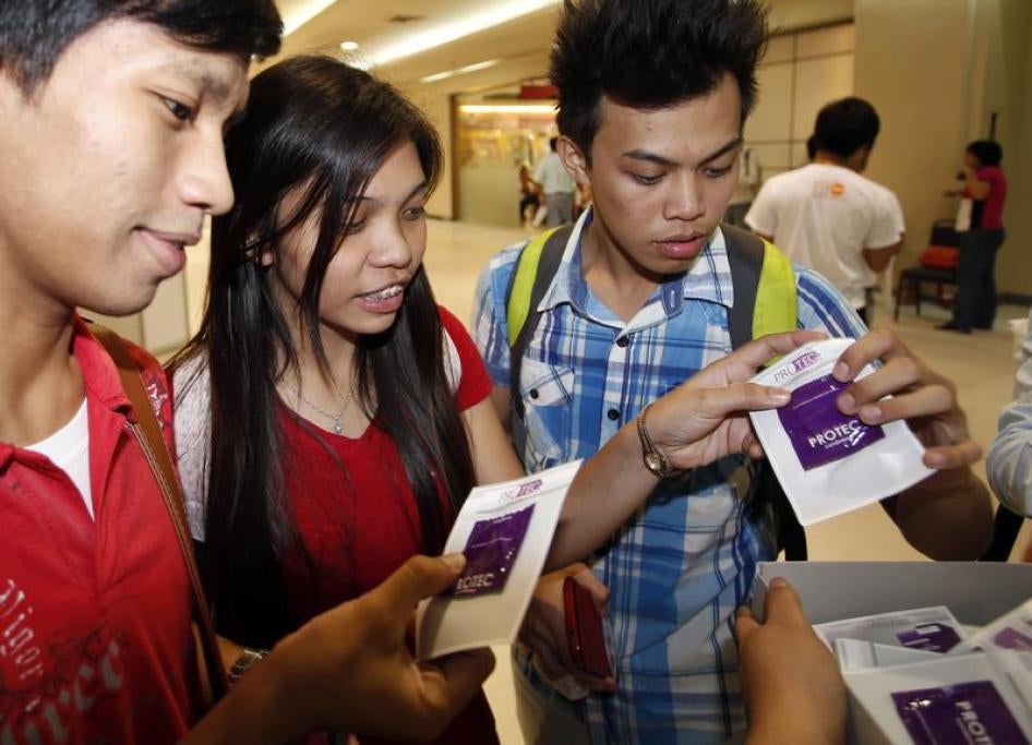Students receive free condoms at an event organized by the United Nations Population Fund (UNFPA) in Metro Manila, July 11, 2014.