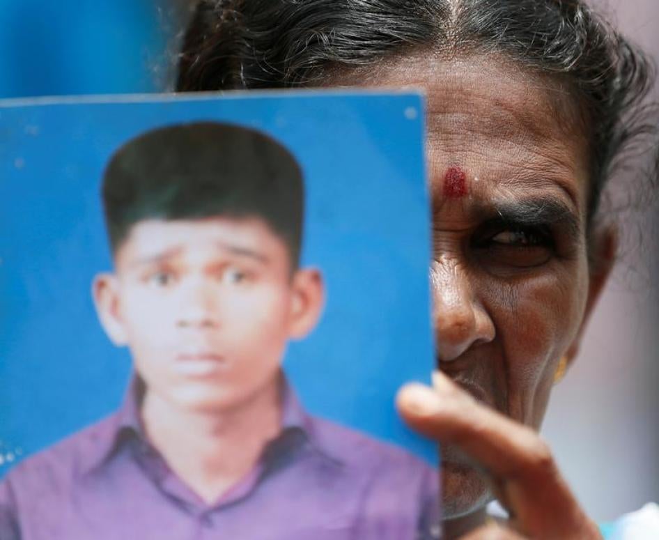 A woman holds up an image of her family member who disappeared during the civil war with the Liberation Tigers of Tamil Eelam (LTTE) at a silent protest to commemorate thethe International Day of the Victims of Enforced Disappearances in Colombo, Sri Lank