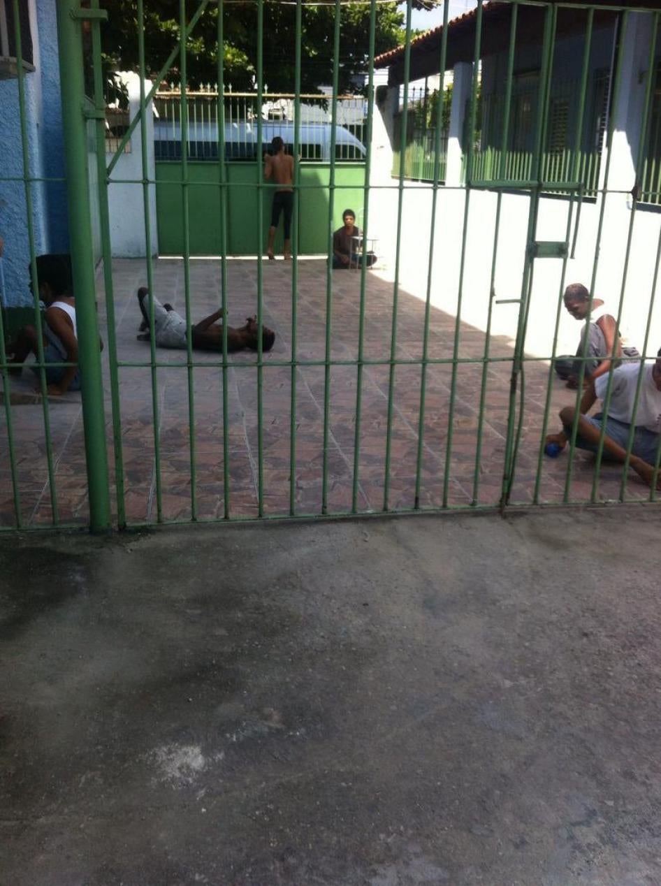 Um grupo de pessoas com deficiência em um pátio de uma instituição no Rio de Janeiro. Residentes ficam do lado de fora por algumas horas durante o dia, mas passam a maior parte do tempo confinados às camas. 