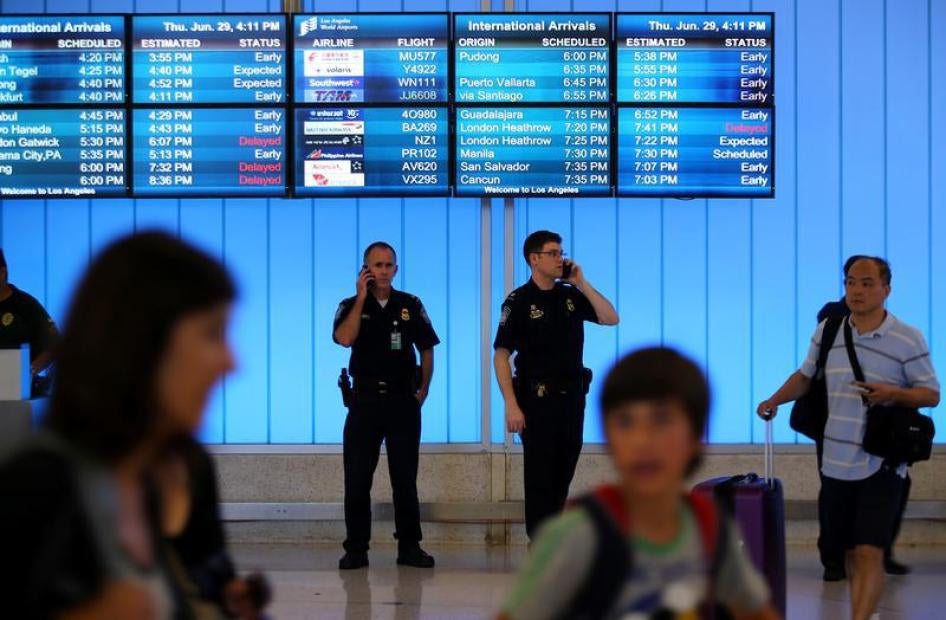 U.S. Customs and Immigration officers keep watch at the arrivals level at Los Angeles International Airport in Los Angeles, California, U.S., June 29, 2017.