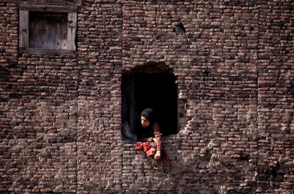 A woman watches the funeral of a civilian who, according to local media, was hit by a police vehicle during a protest after Friday prayers, in Srinagar, June 2, 2018. 