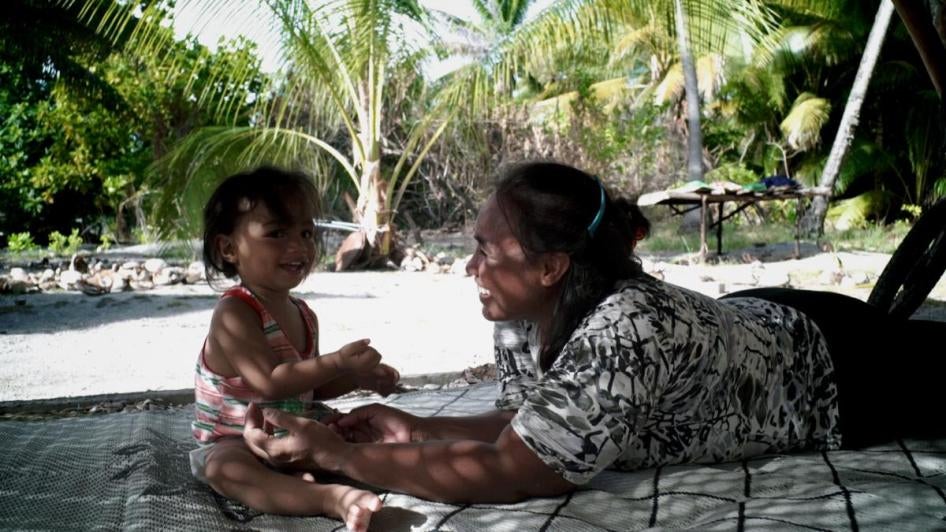 Sermary plays with her baby in Kiribati. Sermary and her family, who move to New Zealand, are featured in the movie Anote’s Ark.