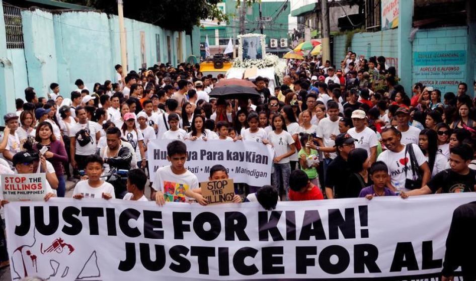Le 26 août 2017, des personnes endeuillées déploient une banderole lors d’une marche funéraire pour Kian delos Santos, un élève de 17 ans qui a été abattu lors d’opérations antidrogues à Caloocan, Grand Manille (Philippines).