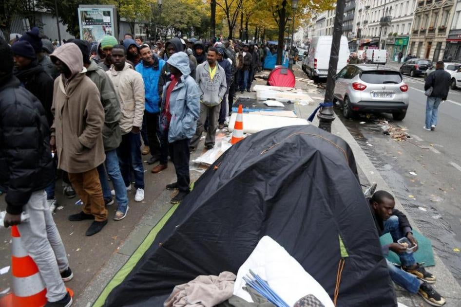 Des migrants font la queue pour recevoir un repas gratuit distribué par l'Agence adventiste du développement et de l'aide humanitaire (ADRA) dans une rue près de la station de métro Stalingrad à Paris (France), le 28 octobre 2016.