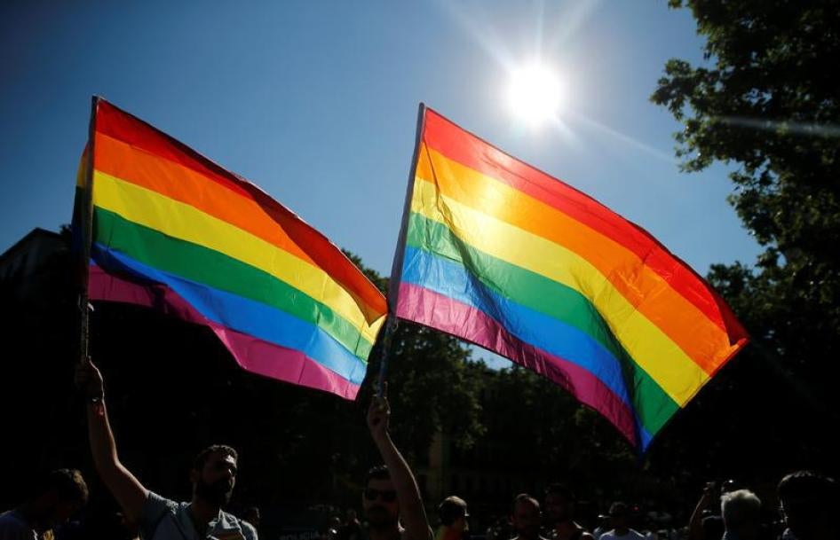 Revellers wave flags during a gay pride parade in downtown Madrid, Spain, July 2, 2016.