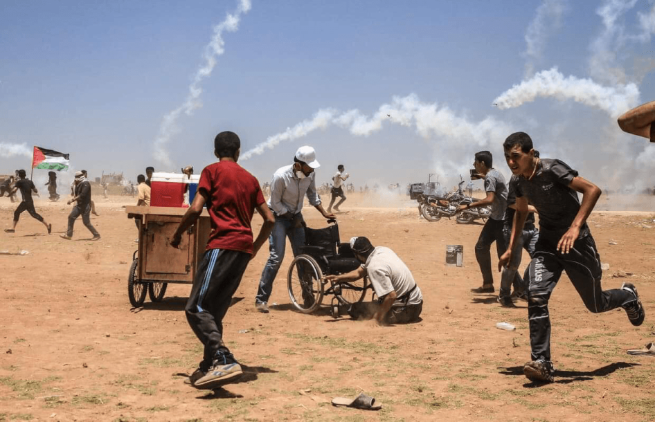 מפגינים פלסטינים נמלטים מגז מדמיע שירו כוחות ישראליים ב-14 במאי בג'באליא שברצועת עזה. (c) מוחמד אבו סלאמה, 2018