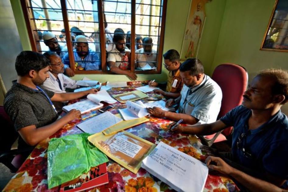 People wait to check their names on the draft list at the National Register of Citizens (NRC) centre at a village in Nagaon district.